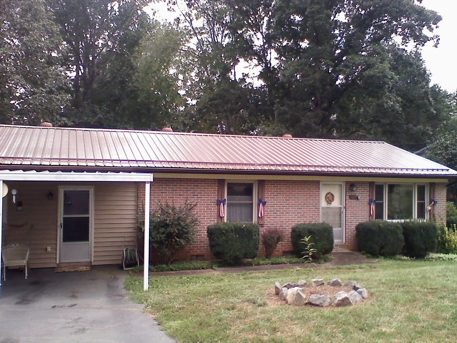 Bronze metal roof and carport on a brick ranch home — Roof Repair work by our crew in Hull
